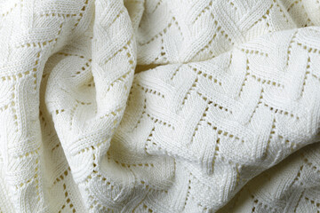 A white knit blanket with a pattern of zigzags. The blanket is soft and cozy, perfect for snuggling...