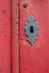 Detalhe de porta vermelha com fechadura de ferro antiga