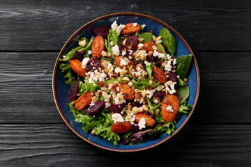 Warm baked carrots and beetroot salad with feta cheese and roasted hazelnuts