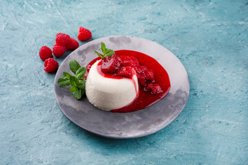 Traditional quark mousse with rhubarb and raspberry compote served as close-up on a Nordic Design plate