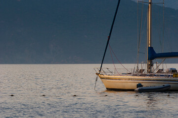 Sailing boat on bleu sunset background. Sailing boat on the sea. A sailboat at anchor in the Gulf of Porto in Corsica.