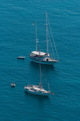 Sailboats at anchor in Corsica. Sailboats floating on the calm blue sea. Coastal summer landscape of Corsica