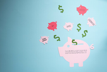 Retirement savings planning concept, IRA, 401K, pension, roth social security.  Piggy bank on blue background.