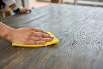 A person is grasping a yellow napkin in their hand while standing