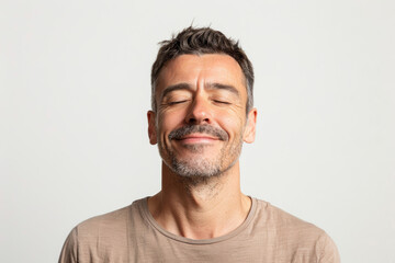 Obraz premium A man with a relaxed smile and closed eyes, separated from the environment, isolated from the background, with no background. Concept of relaxation and tranquility. Generative Ai.