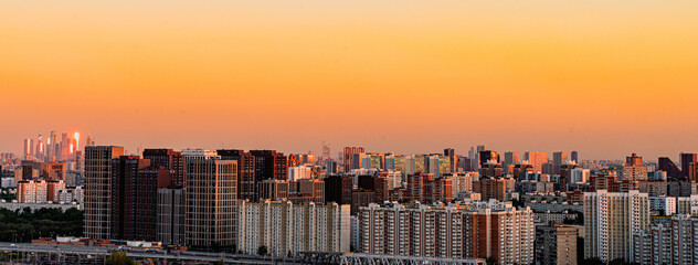 A bird's-eye view of a big city at sunset. Multi-storey residential buildings in the Khovrino...