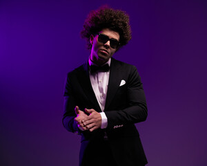 sexy young groom with curly hair and sunglasses rubbing palms