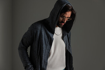 sexy bearded guy with hoodie and gold frame glasses looking down