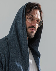 portrait of casual man with gold frame glasses and hoodie