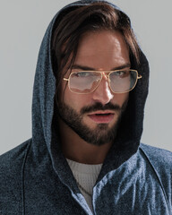 close up picture of sexy bearded man wearing hoodie and gold frame glasses