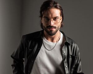 portrait of happy sexy man with glasses in leather jacket smiling