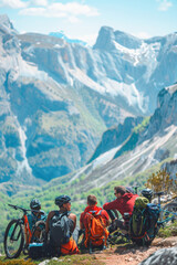 A group of people is sitting on top of a mountain with their bicycles, enjoying the view