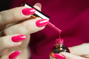 Drop of nail polish close-up. Red manicure with gel polish, beautiful female nails.