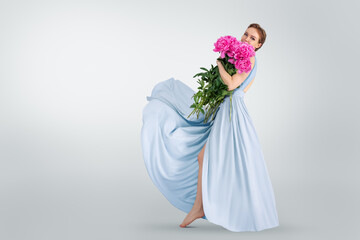 Beautiful Woman Holding Blooming Pink Peonies in Blue Flowy Dress