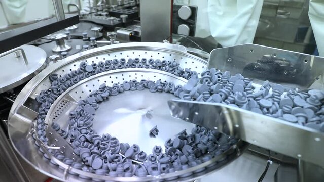rubber stopper putting process on vaccine vials. injection vials. medical drug glass vial caps rotating, sealing, tightening process on pharma equipment machinery pharmaceutical industry