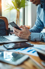 Businessman using smartphone and laptop on the table in office and financial data analyzing counting on calculator pen and notebook
