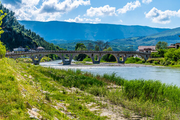 Fototapeta premium A view along the bank of the River Osum towards the Gorica bridge in Berat, Albania in summertime 