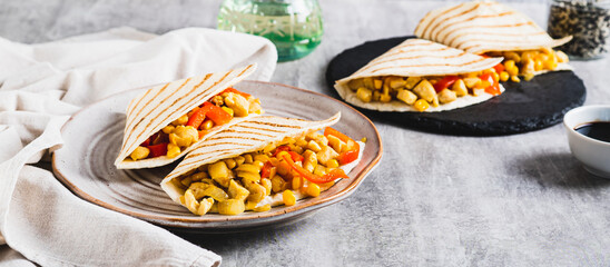 Mexican quesadilla with chicken, corn and bell pepper on a plate on the table web banner