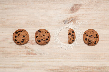 Sweet cookies with chocolate chips on wooden background