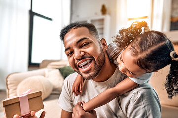 Father's day concept. Dad holds a gift he received from his daughter. Happy family celebrating father's day.