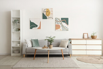 Modern interior of living room with grey sofa, chest of drawers and houseplant on table