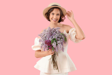 Beautiful young woman with bouquet of blooming lilac flowers on pink background