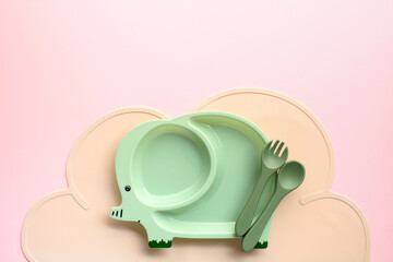 Green elephant-shaped childrens dining set on a pink backdrop. Ideal for content related to kids meals or product ads