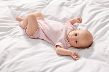 Cute little baby lying on white sheets