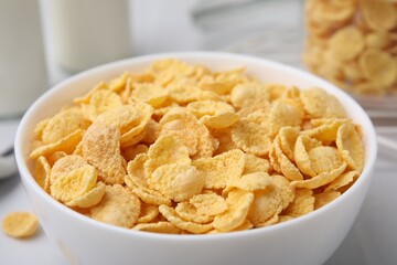 Tasty crispy corn flakes in bowl on table, closeup. Breakfast cereal