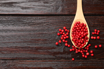 Aromatic spice. Red pepper in spoon on wooden table, top view. Space for text