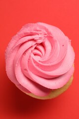 Delicious cupcake with bright cream on red background, top view