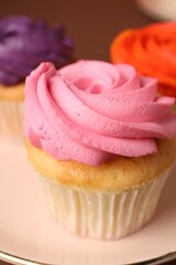 Delicious cupcakes with bright cream on plate, closeup