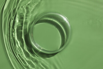 Stylish presentation for product. Glass podium in water on pale green background, top view