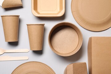 Eco friendly food packaging. Paper containers and tableware on light grey background, flat lay