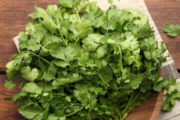 Fresh coriander on wooden table, top view