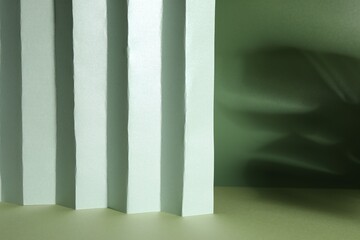 Presentation of product. Paper and shadows on light green background. Space for text
