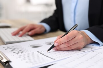 Secretary doing paperwork at table in office, closeup