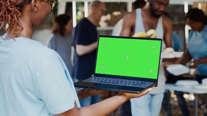 Detailed view of african american female volunteer holding laptop with isolated copyspace display...