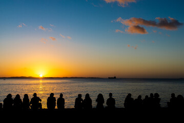 Silhouette of people enjoying the dramatic sunset.