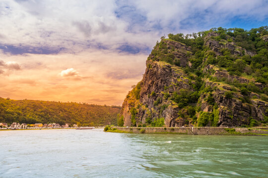 Lorelei rock at sunset. Bank of Rhine river near Sankt Goarshausen town in Rhineland-Palatinate, Germany. Landscape of River Rhein and famous Loreley mountain in Rhine Gorge