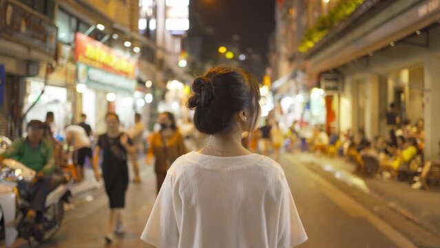 Portrait of happy Asian Vietnamese woman travel at night market people walking street fair in Hanoi city, Vietnam. Retail shops