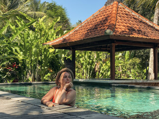 Woman in a straw hat relaxing in the pool