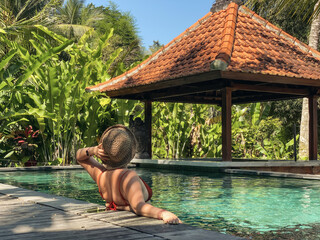 Woman in a straw hat relaxing in the pool