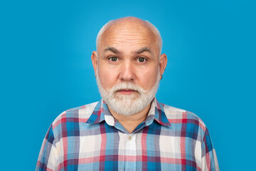 Fototapeta premium Close-up studio portrait of senior man looking at camera. Bearded old aged man, head and shoulders portrait. Older grandfather, grandpa pensioner, retiree concept.