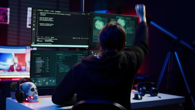 Happy hacker in secret hideout celebrating after managing to hide online activity after stealing data. Cheerful scammer feeling proud after successfully attacking victims using malware, camera B