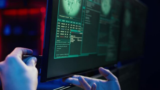 Hacker doing illegal activities in secret underground base, uploading USB flash drive containing data obtained from victim after tricking it into installing ransomware program, camera B