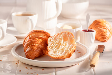 Hot and golden french croissants with jam and butter.