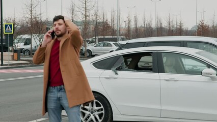 Middle-aged car owner sees broken window calls emergency services crime negative emotions urgent call. Man notices shattered car glass contacts emergency hotline criminal theft immediate response.