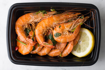 Chinese take out food cooked shrimp with lemon in a container