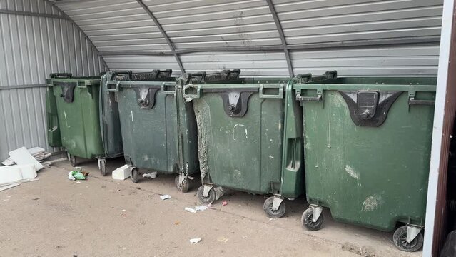 Row of green garbage cans are used for waste containment and garbage collection located in special place for food waste